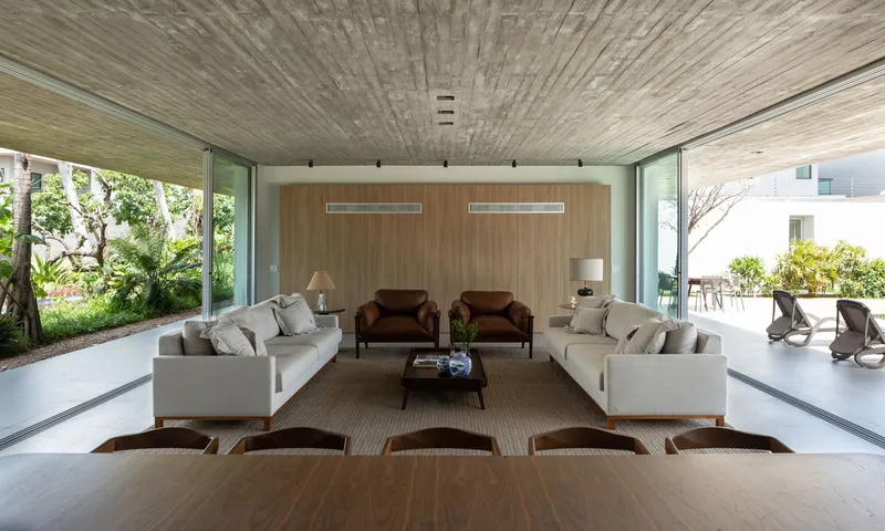 Living area looking toward timber-clad wall flanked by glazed openings to exterior courtyards and garden