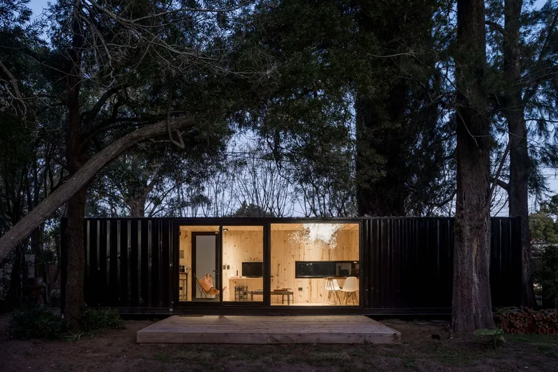 Front elevation showing the symmetrical black corrugated facade with central glazed opening