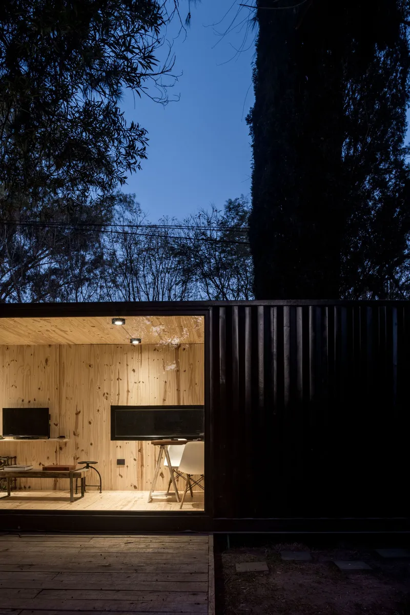 Detail of the plywood-lined interior framed by the vertical corrugated cladding at twilight