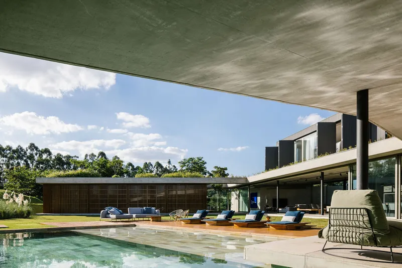 Pool deck with timber canopy soffit and lounge furniture under a partly cloudy sky