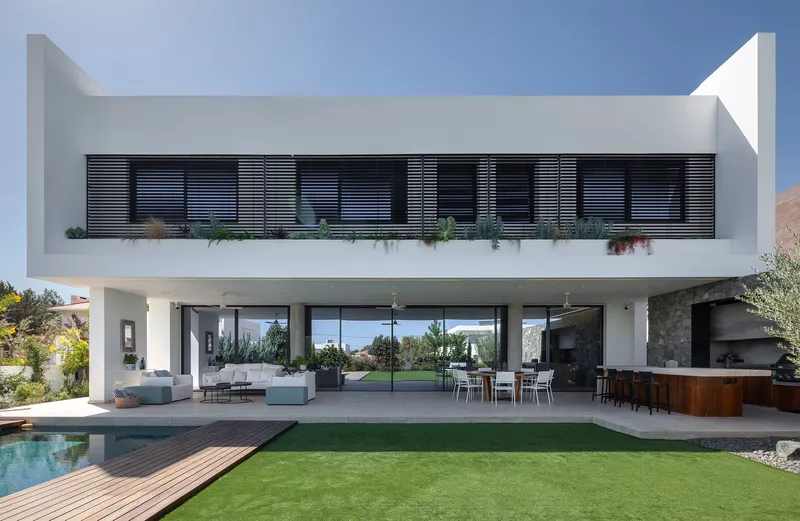 Garden facade showing horizontal louvers on the upper balcony above the open living terrace and pool
