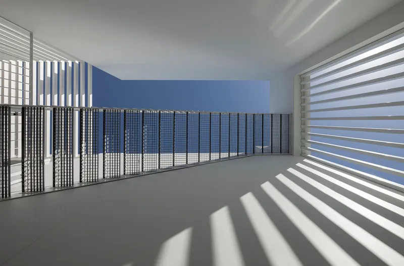 Upper level corridor with horizontal louvers casting striped shadows across white floors and blue wall