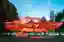The image showcases a contemporary pavilion in an urban park setting. The structure features a strik