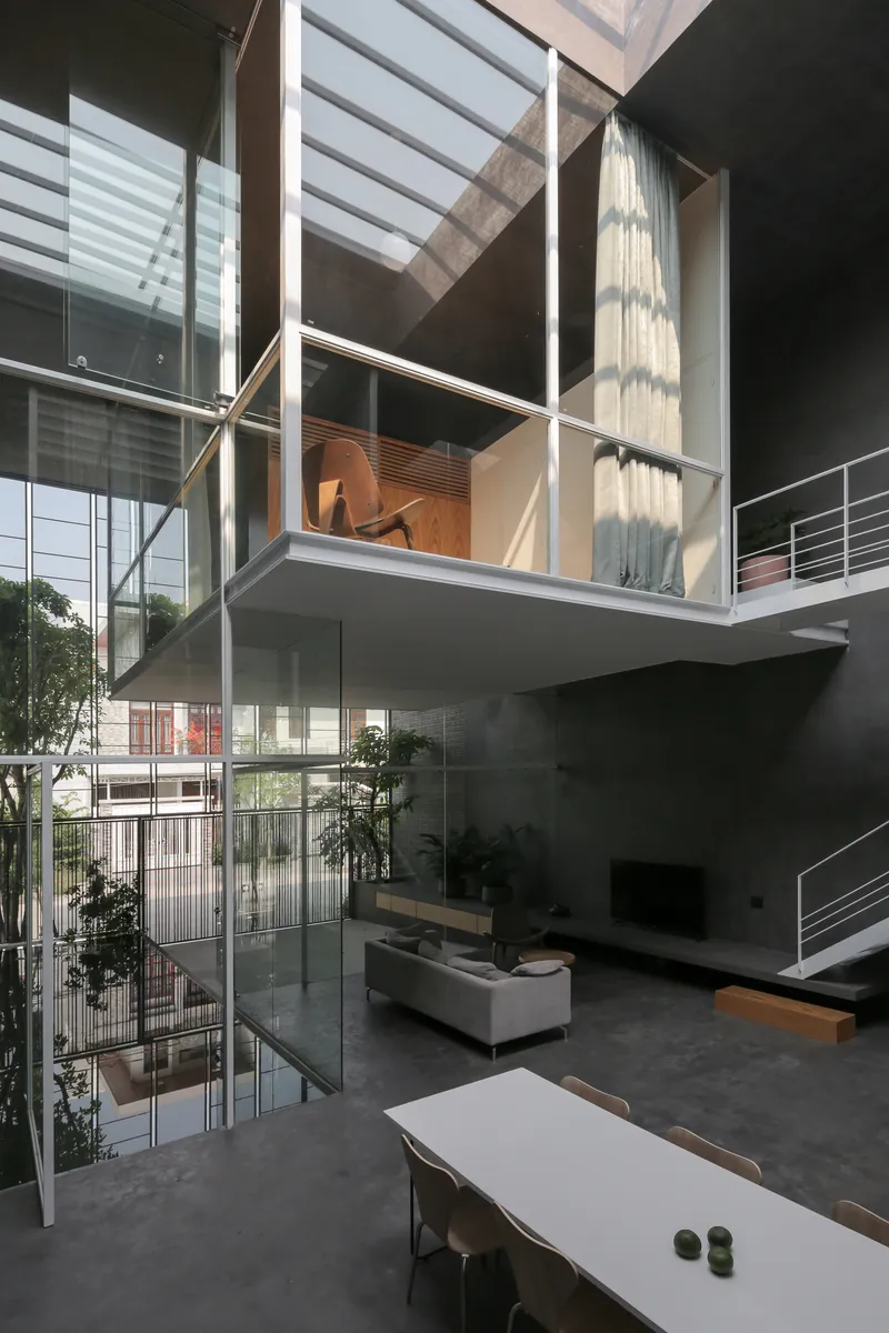 Interior view of cantilevered mezzanine with white steel frame overlooking the double-height living space below