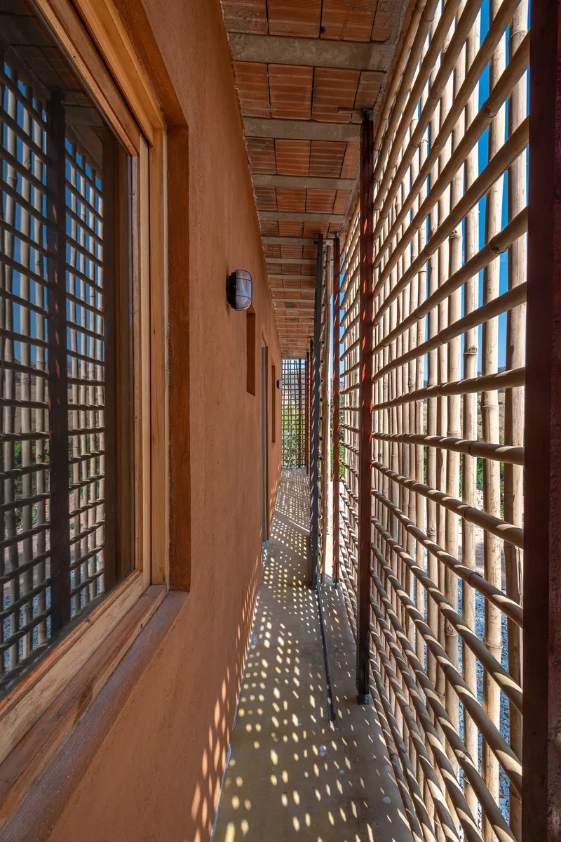 Narrow passage flanked by lattice screens creating patterns of light and shadow on the pathway