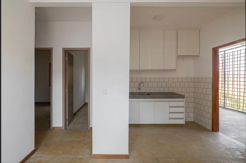 Open plan kitchen with white subway tile backsplash and bamboo lattice window under timber ceiling