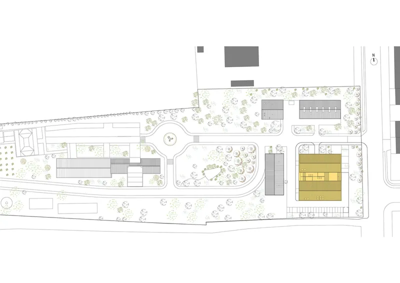 Site plan drawing showing the footprint highlighted in yellow among surrounding buildings and landscaping