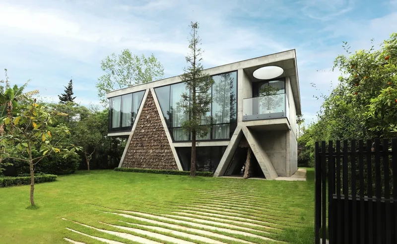 Elevated concrete volume on angled columns with textured triangular chimney and continuous glass facade facing a lawn