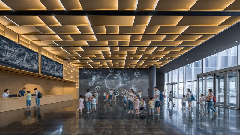Entry lobby with coffered timber ceiling and visitors gathered before a projection wall