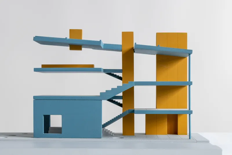 Sectional model revealing interconnected floor plates with diagonal staircases threading through yellow cores