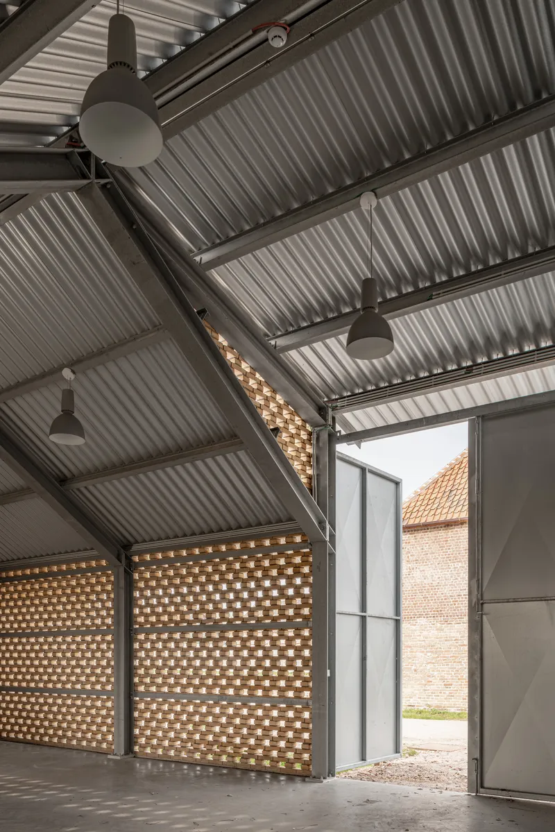Large doors opening from interior space to courtyard framed by perforated brick screens