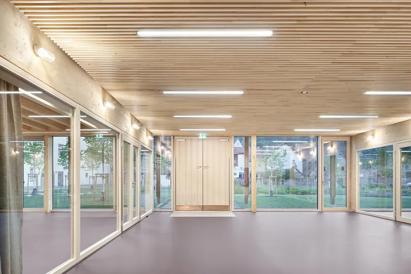 Interior corridor with slatted timber ceiling, glass walls and grey resin flooring
