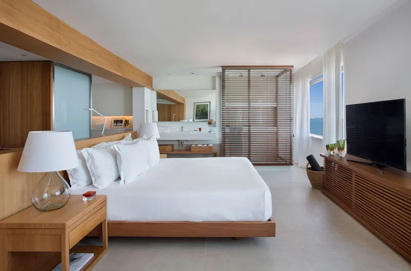 Timber bed platform and slatted screen with ensuite vanity visible through open doorway