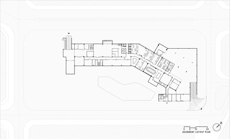 Basement level floor plan showing an angled circulation spine connecting service and support spaces