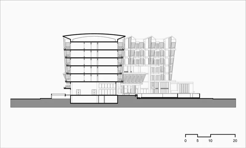 Section drawing showing the curved-roof volume beside the rectilinear residential bar with pitched roofs