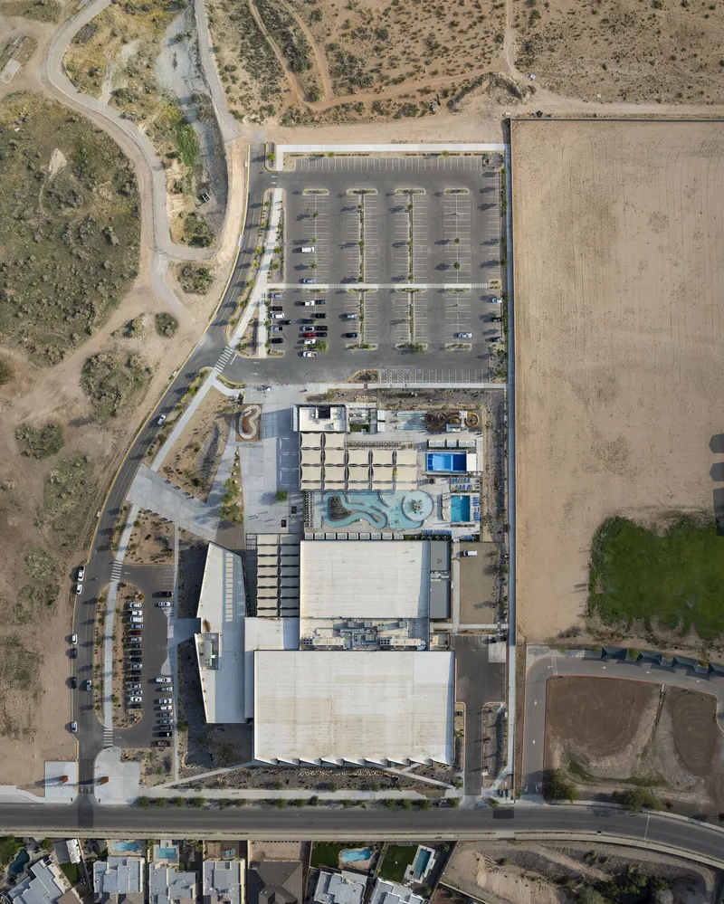 Aerial view of rooftops, parking lot, and surrounding desert terrain with access roads