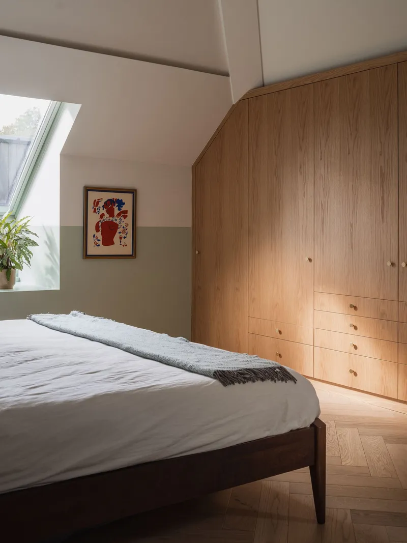 Bedroom with built-in oak wardrobe and natural light from a skylight window