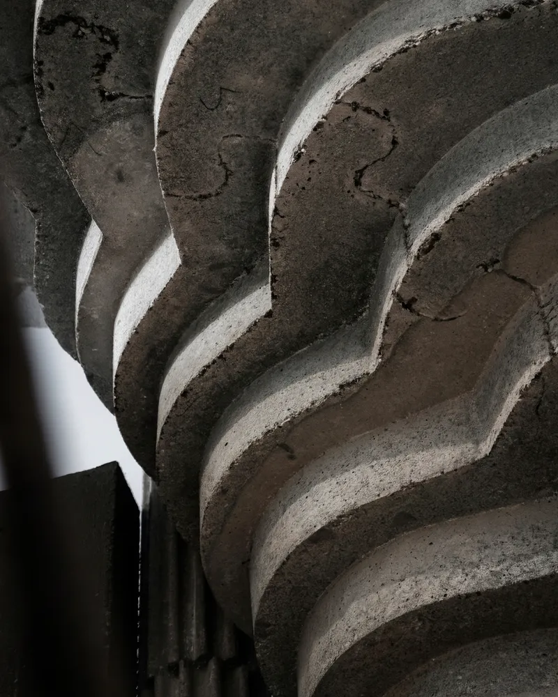 Close-up of the undulating concrete staircase soffit showing layered formwork texture