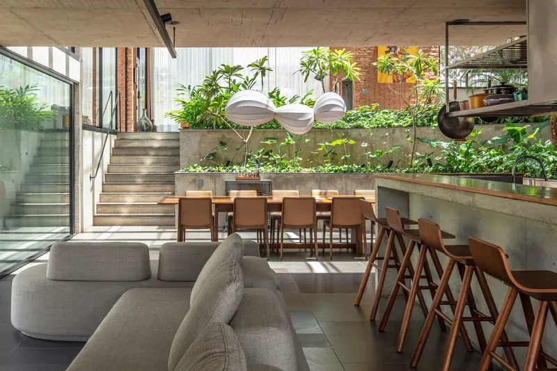 Split-level dining area with terraced concrete planters and timber stairs ascending to upper levels