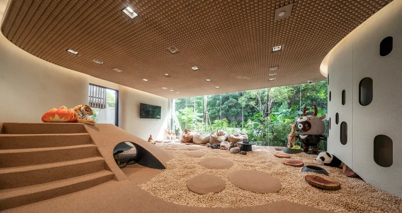 Play area with textured cork ceiling and gravel floor looking out to garden