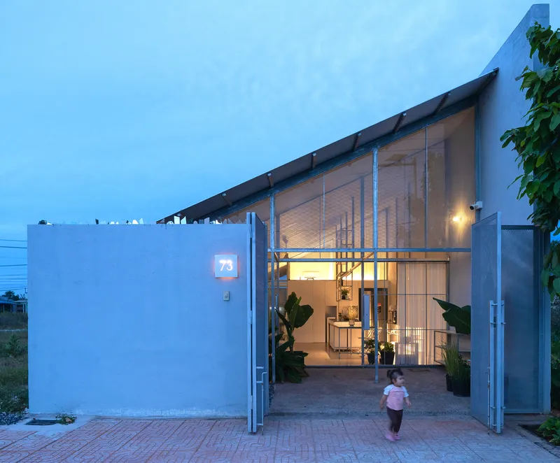 Open entrance gate with child walking through courtyard at twilight