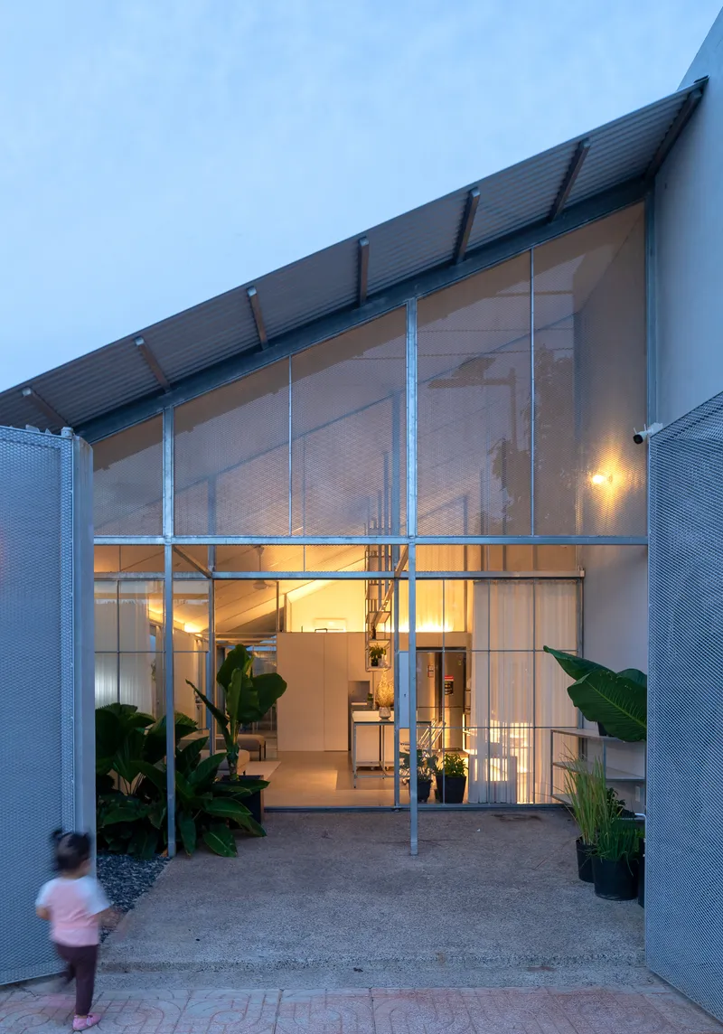 Front elevation showing steel frame entrance and translucent screens flanked by banana plants