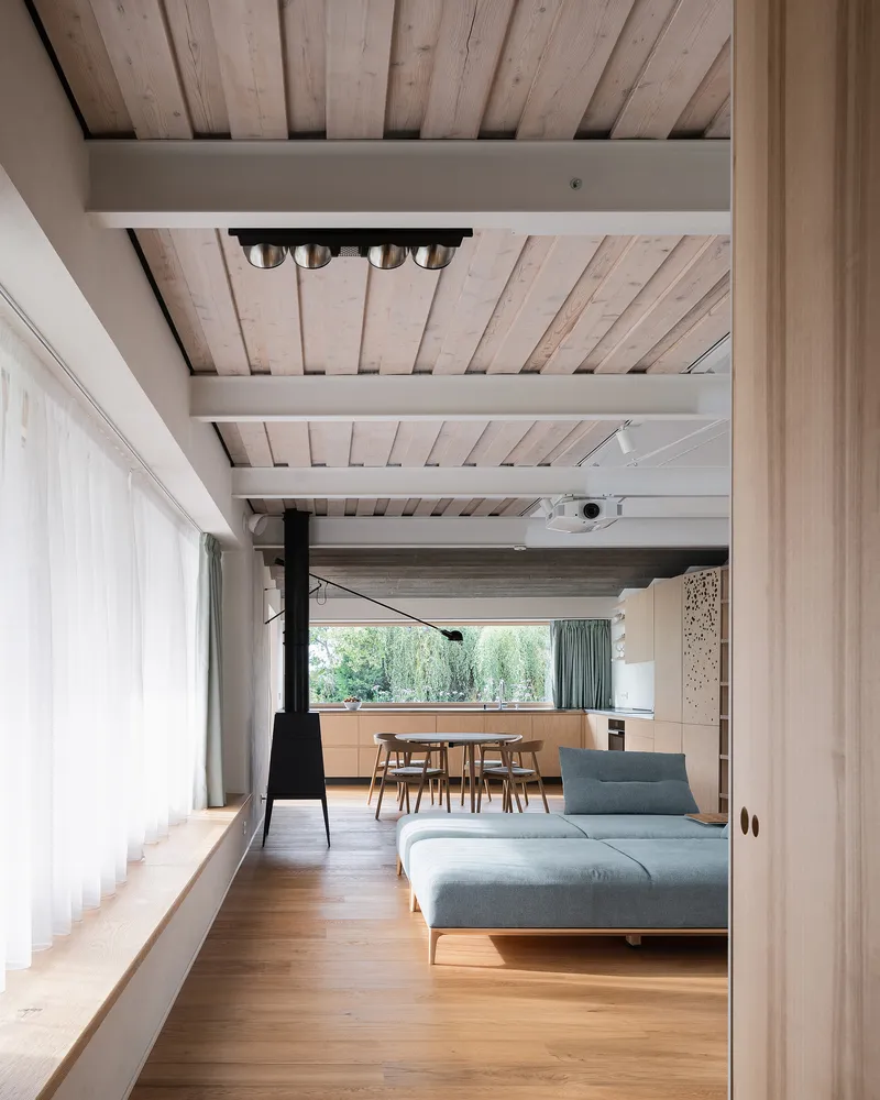 Living space with exposed timber ceiling beams, steel joists and oak flooring