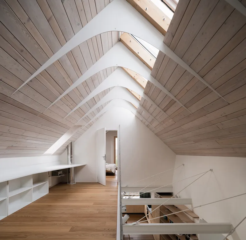 Attic space with timber-lined pitched ceiling, skylights and view through to bedroom
