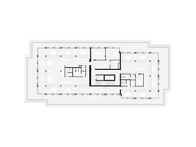 Floor plan drawing depicting an open workspace with central core and enclosed rooms along the perimeter