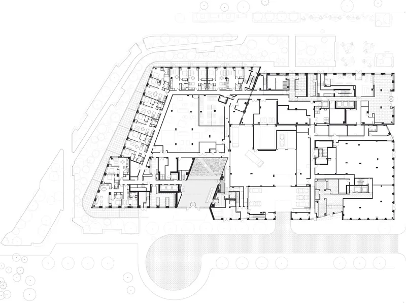 Floor plan drawing showing an angular complex with multiple courtyards and a curved roadway along one edge