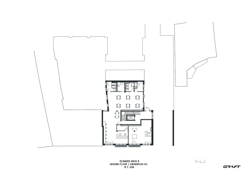 Ground floor plan drawing showing an open workspace with seating clusters and a central staircase
