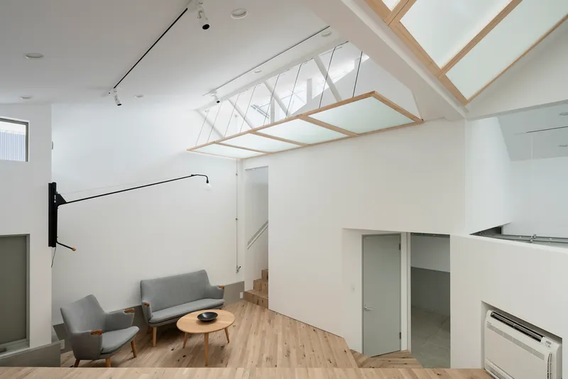 Suspended rectangular timber and panel frame beneath a gabled skylight with diagonal bracing