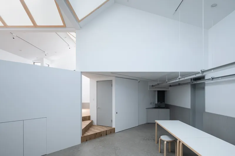 Open kitchen and dining area with exposed ductwork and timber-framed skylights above
