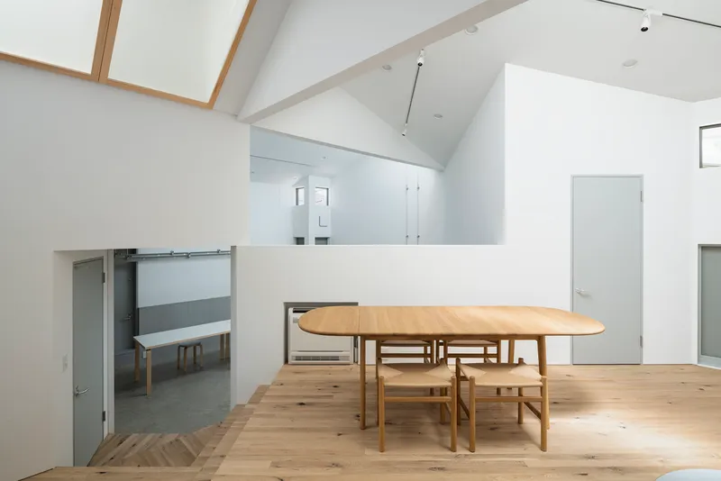 Mezzanine dining area with timber flooring overlooking the lower level concrete floor and sliding door below