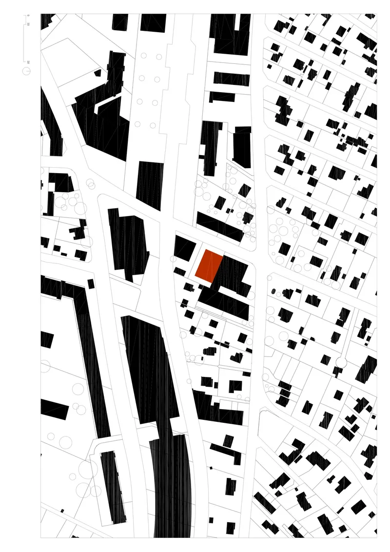 Site plan drawing showing the building footprint in orange among surrounding urban blocks in black