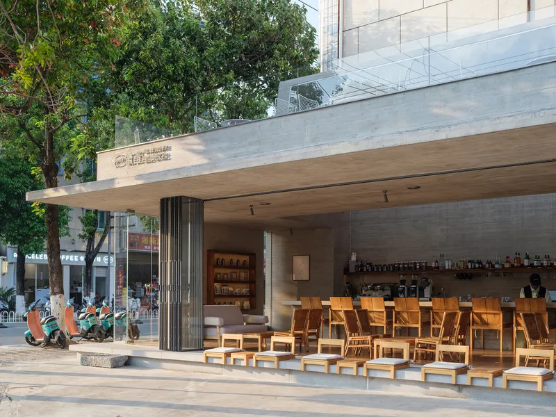 Covered outdoor seating area with timber furniture and concrete canopy with wood soffit
