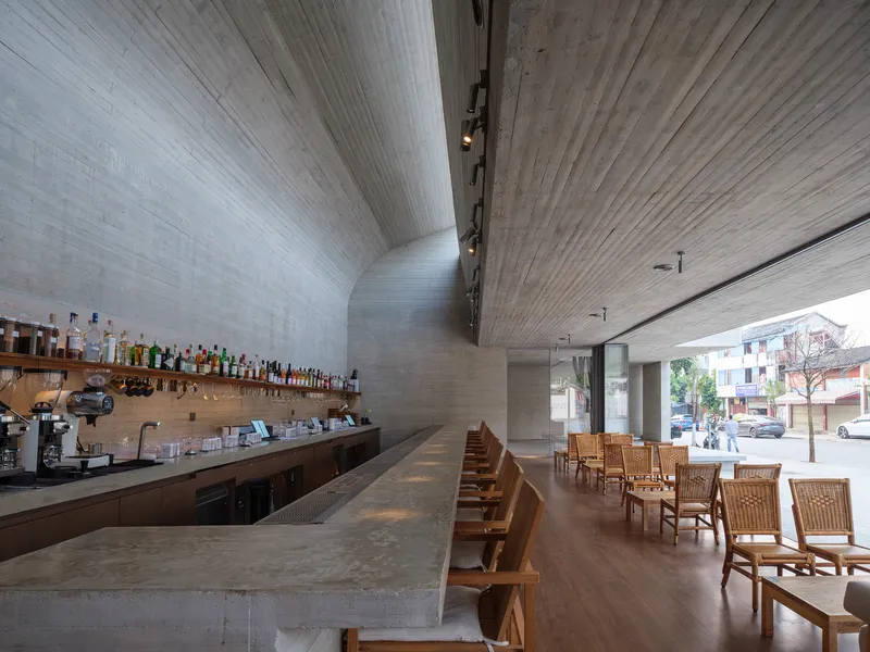 Interior view of the bar counter and seating with board-formed concrete ceiling planes