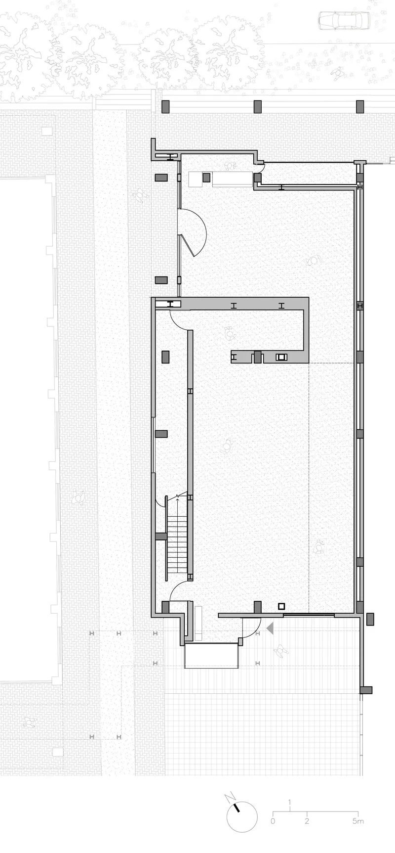 Ground floor plan drawing showing two open volumes with central staircase and adjacent landscape