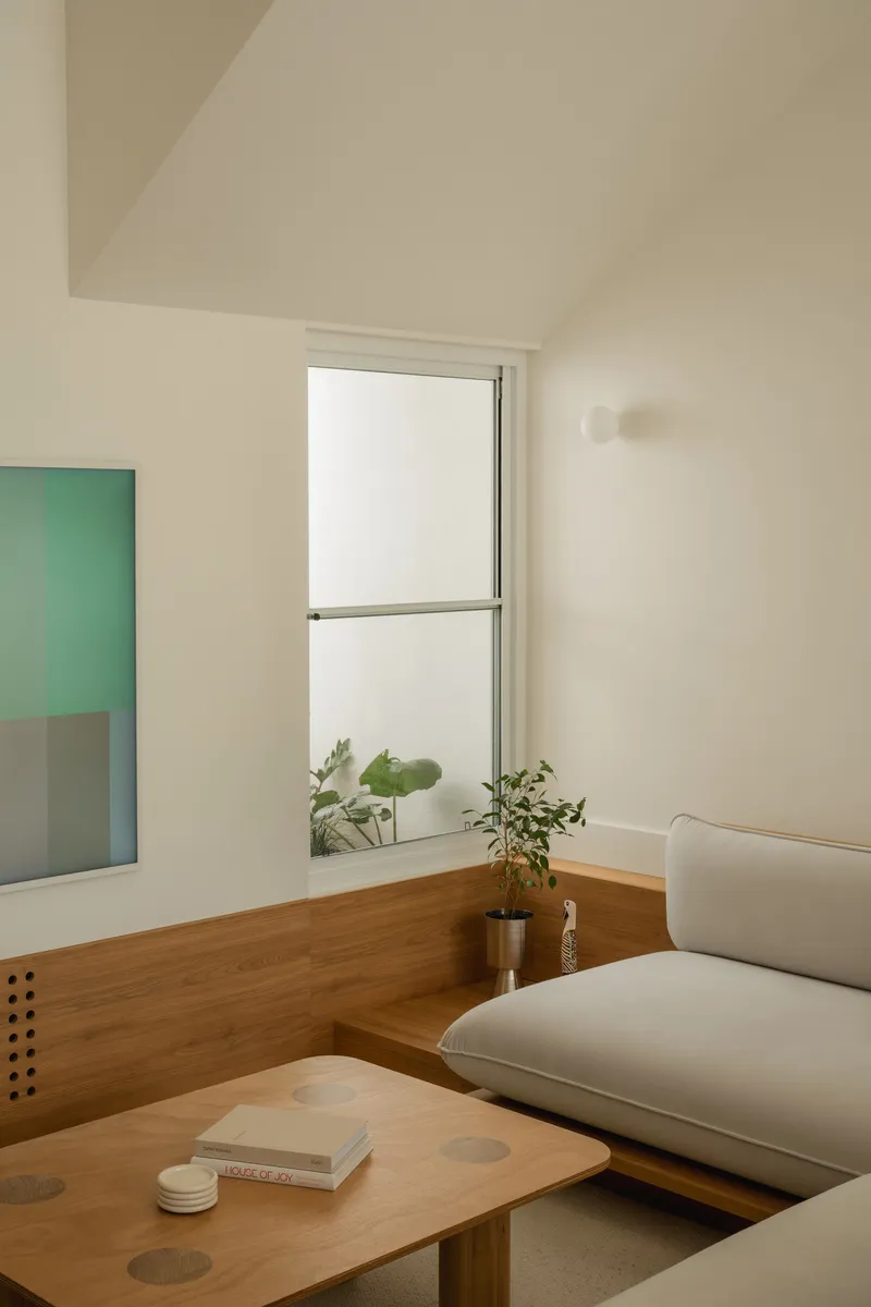 Timber window ledge with potted plants beside built-in seating in daylight