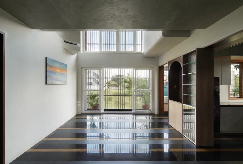 Interior with polished striped floor reflecting light from vertical louver windows overlooking the landscape