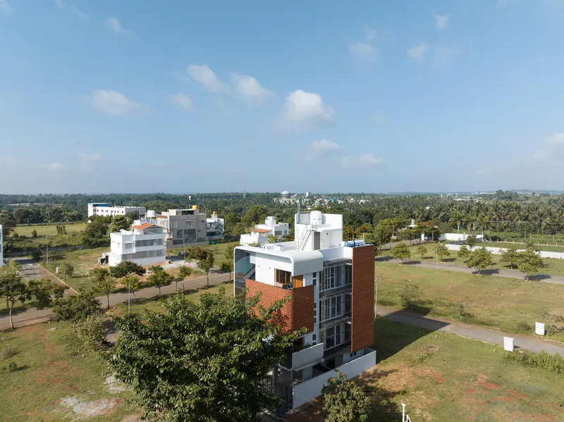 Aerial view of the tower set within a landscaped residential development with scattered trees and open fields