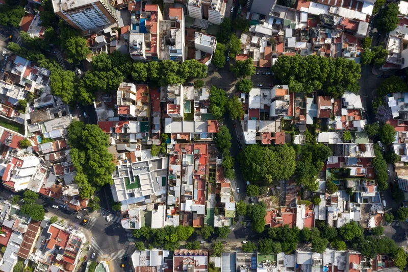 Aerial view of a dense residential neighborhood with terracotta rooftops and tree-lined streets