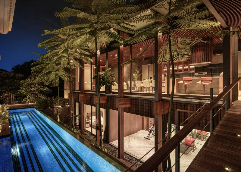 Evening view from the poolside terrace showing timber framing and tree ferns overhead