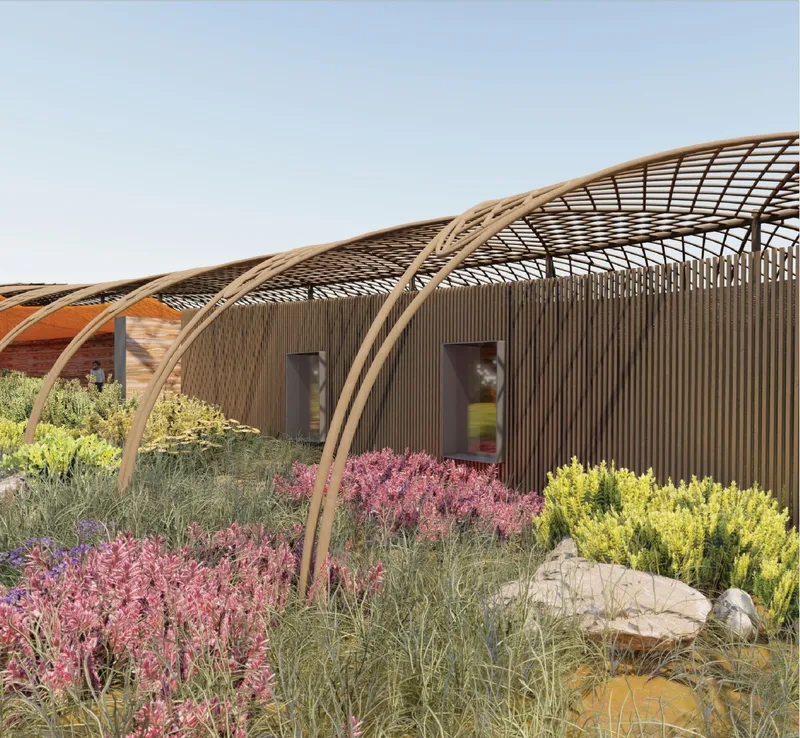 Bamboo-clad residential units merge with lush native planting beneath lightweight trellis structures and shaded pathways.