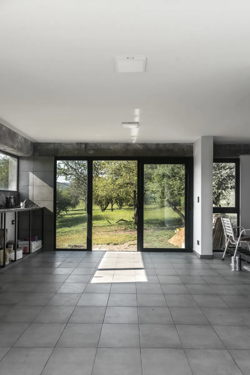 Open living space with gray tile floor and sliding glass doors opening to garden