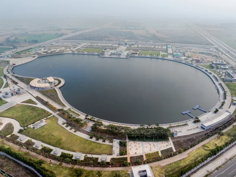 Aerial view of the circular reservoir encircled by a landscaped promenade under hazy daylight