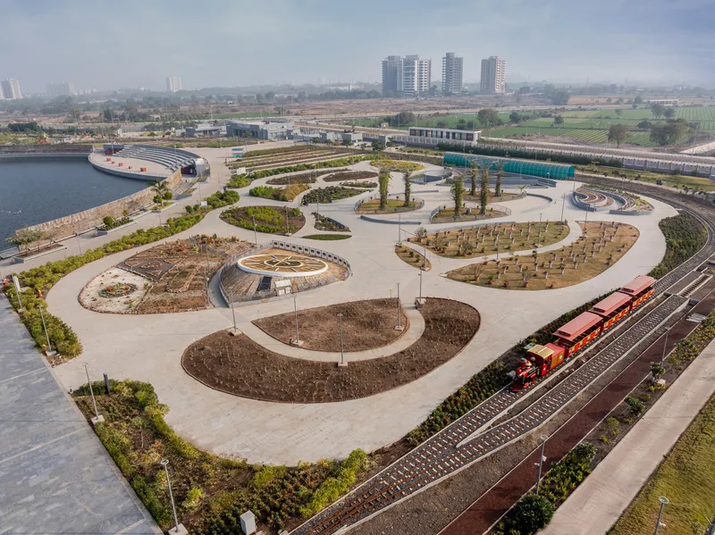 Aerial view of interlocking circular planting beds bordered by paved pathways and railway tracks