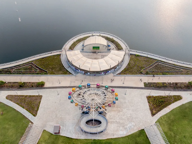 Overhead view of the circular pavilion and paved plaza with a miniature ferris wheel installation