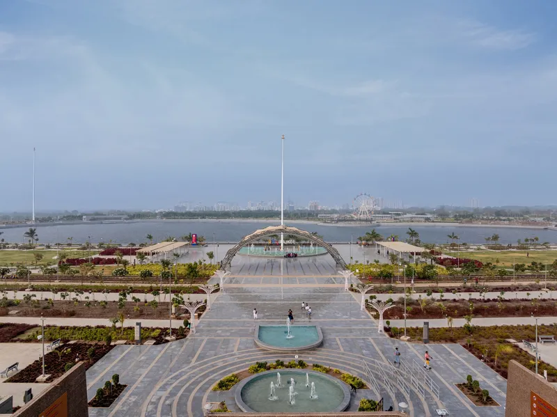 Central axis looking toward the arched canopy structure with circular fountains and terraced landscaping beds