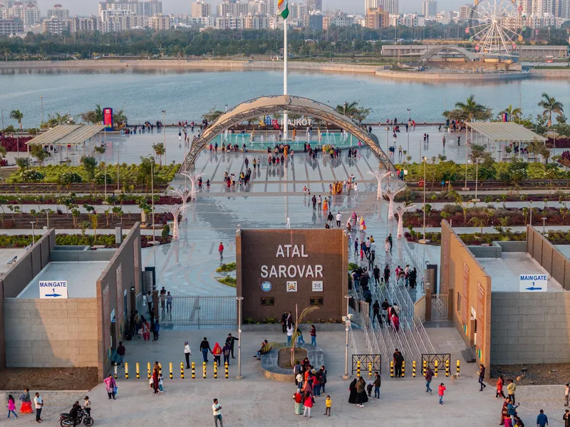 Elevated view of central plaza with arched canopy and visitors approaching through entry gates at sunset